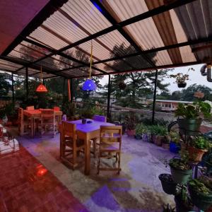 patio con tavoli e sedie sotto un pergolato di Hotel Encuentro del Viajero a Panajachel