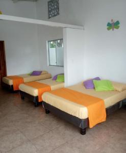 un grupo de 3 camas en una habitación en Olimpia Habitaciones Departamentos, en Atacames