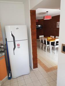 a white refrigerator in a kitchen with a table at Departamentos El Colono Duplex 2 in Viedma
