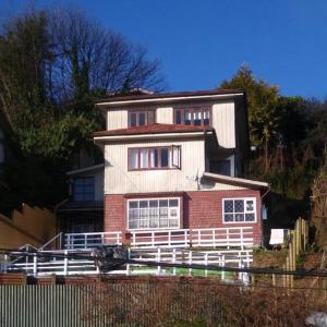 uma casa com uma cerca branca em frente em Islanet Hostel & Bar em Puerto Montt