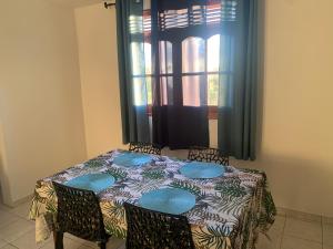 mesa de comedor con sillas y ventana en Villa Karata Appartement T3 avec Spa et vue sur mer BAILLIF Basse-Terre, en Baillif