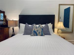 a large bed with blue and white pillows on it at The Residence Stylish Comfort with Fireplace in Tenterfield