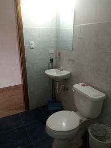 a bathroom with a toilet and a sink at Olimpia Habitaciones Departamentos in Atacames