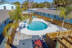 una vista sul tetto di una piscina con palme e di una casa di Salt Air Inn & Suites ad Atlantic Beach