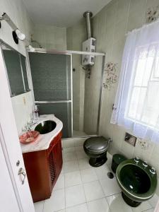 a bathroom with a green toilet and a sink at Apartamento aconchegante em condomínio encantador. in Lambari