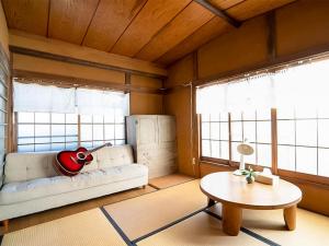 a living room with a couch and a table at Guest House Irodori Kamakura in Kamakura