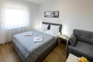 a hotel room with a bed and a couch at MB Apartment 2 in Subotica