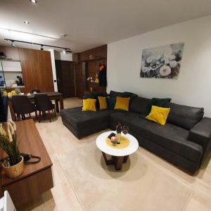 a living room with a black couch and a table at MK Apartments Zoned 2 Spa&Wellness in Cajetina