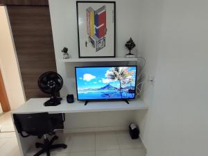 einen Flachbild-TV auf einem weißen Tisch in der Unterkunft Aconchego Encantador in Viçosa
