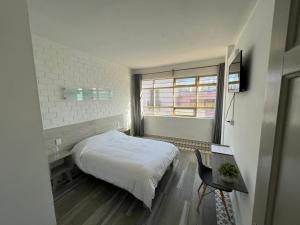- une chambre avec un lit, une table et une fenêtre dans l'établissement Hotel Insurgentes, à San Luis Potosí