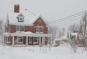 a red brick house with snow on top of it at Napier House in Campbellton