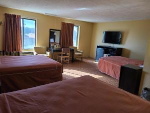 a hotel room with two beds and a television at Budgetel inn & Suites in Fort Scott
