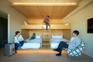 a group of people in a room with bunk beds at FAV HOTEL KUMAMOTO in Kumamoto