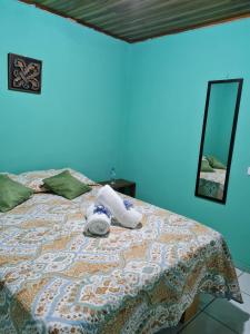 Una cama con una toalla y un espejo. en HopeCR en Alajuela City