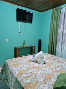 1 dormitorio con 1 cama y TV en la pared en HopeCR en Alajuela City