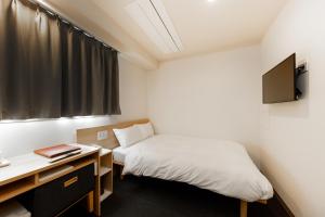 A bed or beds in a room at HOPETREE OSAKA GRAND