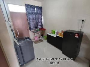 een kleine badkamer met een koelkast en een raam bij AYUNI HOMESTAY KUALA BESUT TERENGGANU in Kampung Kuala Besut