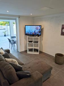 a living room with a couch and a flat screen tv at L'améthyste in Saint-François +70 photos