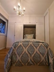 1 dormitorio con cama y lámpara de araña en Avenida General Las Heras en Buenos Aires