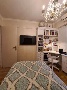 a bedroom with a bed and a desk and a chandelier at Avenida Las Heraas in Buenos Aires