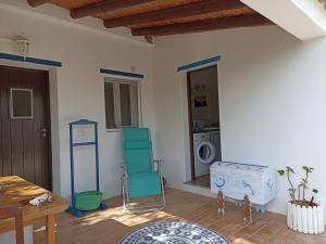 een woonkamer met een stoel en een wasmachine bij Charming Cottage near Tavira in Juliãos