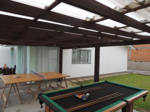 a pool table in a backyard with awning at casa piscina pinheira -sc in Palhoça