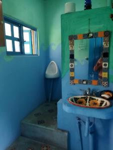 Baño azul con lavabo y espejo en Casa Ecológica, en Tepoztlán