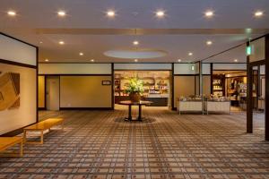 a lobby of a store with a table and flowers at Towada Hotel in Kosaka