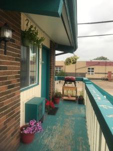 a porch with potted plants on a house at RANCHLAND Inn in Nanton