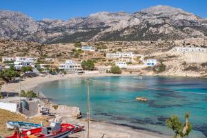 a beach with a red boat on the shore at THE SHIP 2 in Karpathos