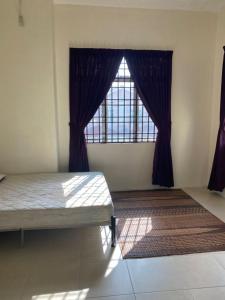 Homestay Chik Da في Kampong Alor Senjaya: غرفة نوم بسرير ونافذة كبيرة