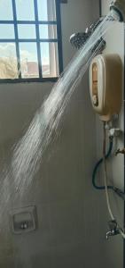 a bathroom with a shower with water coming out of it at Homestay Chik Da in Kampong Alor Senjaya