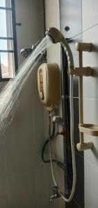 La salle de bains est pourvue d'une douche avec flexible d'eau. dans l'établissement Homestay Chik Da, à Kampong Alor Senjaya