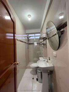 bagno con servizi igienici, lavandino e specchio di Apartamento exclusivo en Cusco cerca al aeropuerto a Cuzco