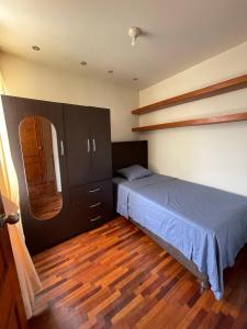 a bedroom with a bed and a wooden floor at Exclusivo Apartamento en el corazón de Trujillo in Trujillo