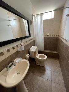 y baño con lavabo, aseo y espejo. en Exclusivo Apartamento en el corazón de Trujillo en Trujillo