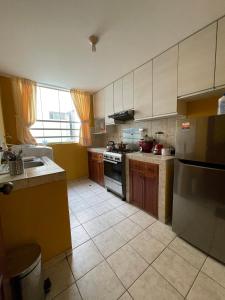 uma cozinha com um lavatório e um fogão em Exclusivo Apartamento en el corazón de Trujillo em Trujillo