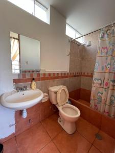 y baño con aseo, lavabo y espejo. en Exclusivo Apartamento en el corazón de Trujillo en Trujillo