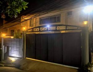 um portão em frente a uma casa à noite em McHanns Place em Antipolo