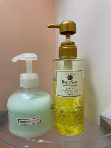 une bouteille de savon et un distributeur de savon sur une étagère dans l'établissement HotelHarmony日暮里ホテルハーモニー, à Tokyo