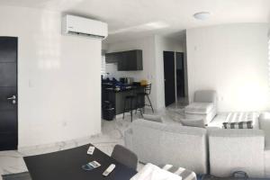 ein Wohnzimmer mit Sofas und einem Tisch sowie eine Küche in der Unterkunft ACAPULCO DIAMANTE!! HERMOSO DEPARTAMENTO NUEVO!! in Acapulco