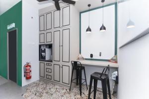 a kitchen with a table and two black stools at OYO 90399 Green Home Hotel syariah in Sepang