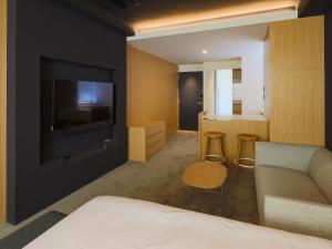 una camera d'albergo con un letto e una televisione di Hotel Muso a Kyoto