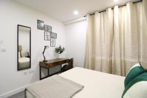 a bedroom with a bed and a mirror at Virexxa Bedford Centre - Deluxe Suite - 2Bed Flat with Free Parking & Gym in Bedford