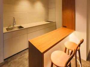 a kitchen with a counter with two chairs and a sink at Hotel Muso in Kyoto