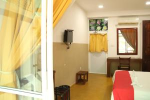 a room with a bed and a window and a tv at Ran Dhara Beach Resort in Ambalangoda