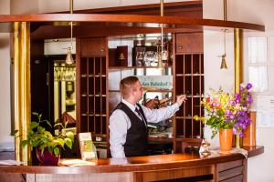 a man is standing behind a counter in a bar at Hotel am Bahnhof in Stendal