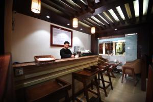 un uomo in piedi dietro un bancone di un ristorante di Karma Hotel Nepal a Kathmandu