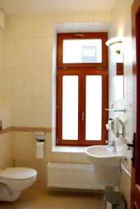 ein Bad mit einem WC, einem Waschbecken und einem Fenster in der Unterkunft Hotel Most Slávy in Trenčianske Teplice