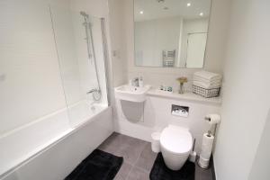 a white bathroom with a toilet and a sink at Virexxa Bedford Centre - Premier Suite - 2Bed Flat with Free Parking & Gym in Bedford